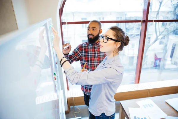 Geconcentreerd studenten permanent en het schrijven op het whiteboard in klas — Stockfoto