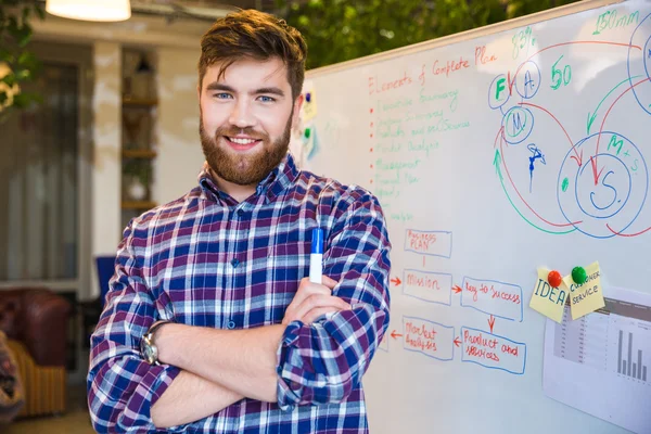 Happy young businessman standing in office — Stock Photo, Image