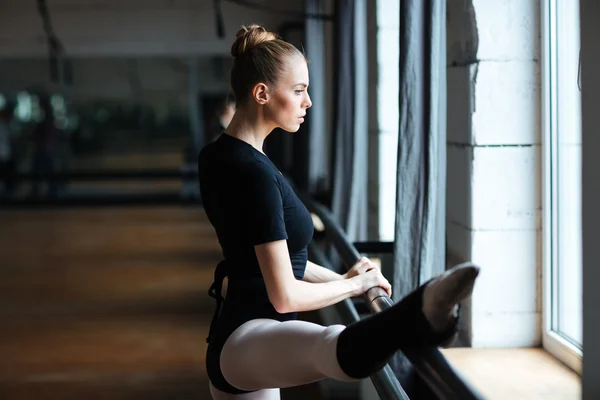 Bailarina alongamento perna na aula de balé — Fotografia de Stock