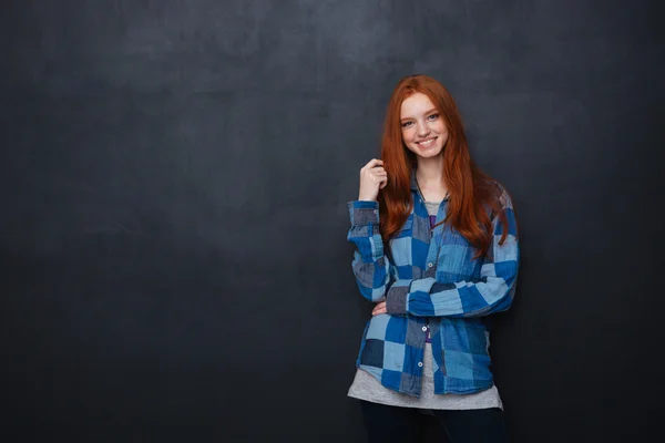 幸福的女人，与红色的头发站在黑板的背景 — 图库照片