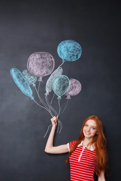 Happy nainen tilalla ilmapalloja piirretty liitutaulu tausta — kuvapankkivalokuva