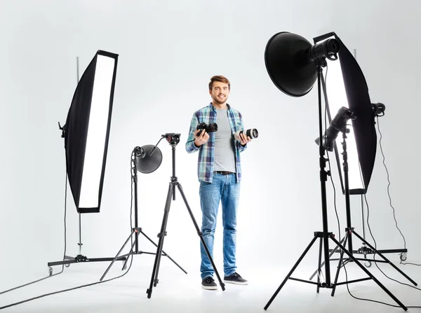 Fotograf steht mit Ausrüstung im Studio — Stockfoto