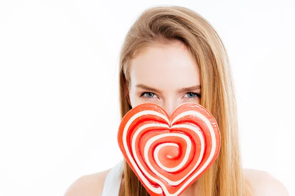 Niedliche schöne junge Frau bedeckt Gesicht mit Heatr förmigen Lutscher — Stockfoto