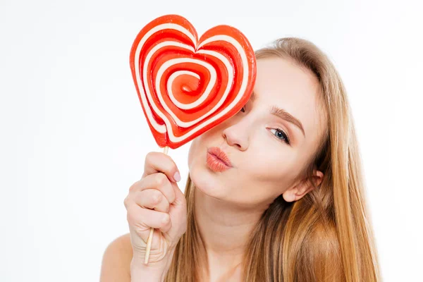 Charmante verspielte Frau mit herzförmigem Lutscher, die einen Kuss schickt — Stockfoto