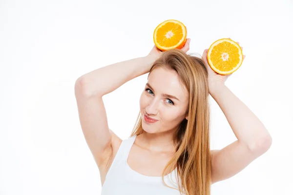 Figlarny kobieta radosna trzymając dwie połówki pomarańczy nad jej głową — Zdjęcie stockowe