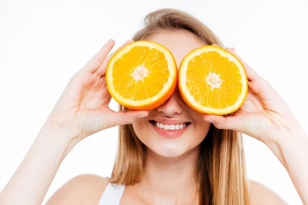 Zabawny wesoły kobieta trzymając dwie połówki pomarańczy przed oczami — Zdjęcie stockowe