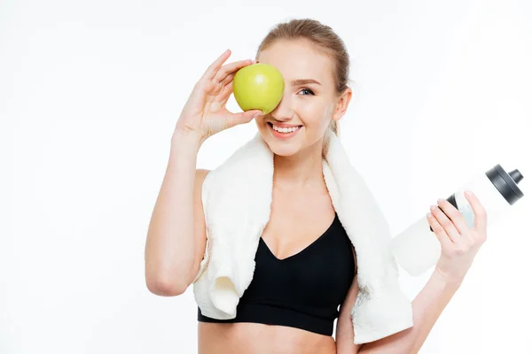 Glada söta unga idrottskvinna täckt öga med äpple — Stockfoto