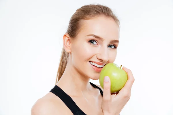 Cheerful woman athlete eating an apple — Stock Photo, Image