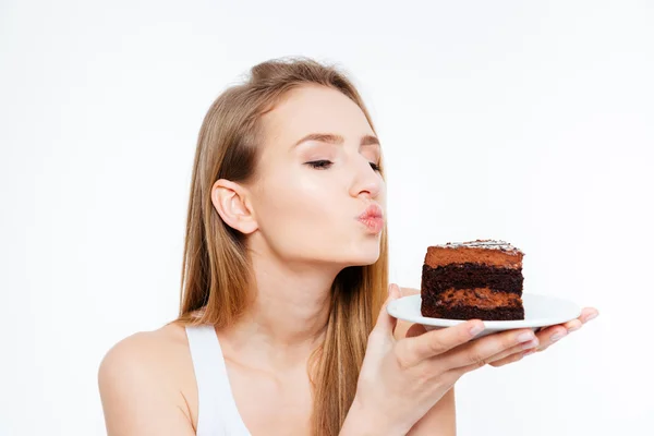 Γυναίκα κρατώντας κομμάτι του κέικ σοκολάτας και να στέλνει ένα φιλί — Φωτογραφία Αρχείου