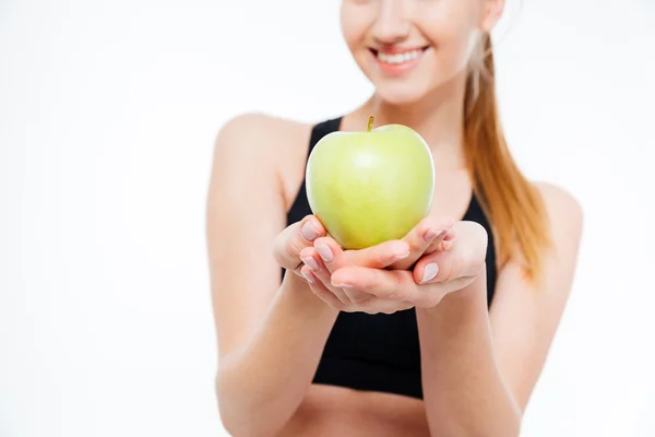 Fresh green apple holded by cheerful woman athlete — Stock Photo, Image
