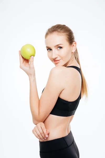 Charmante Sportlerin steht und posiert mit Apfel — Stockfoto