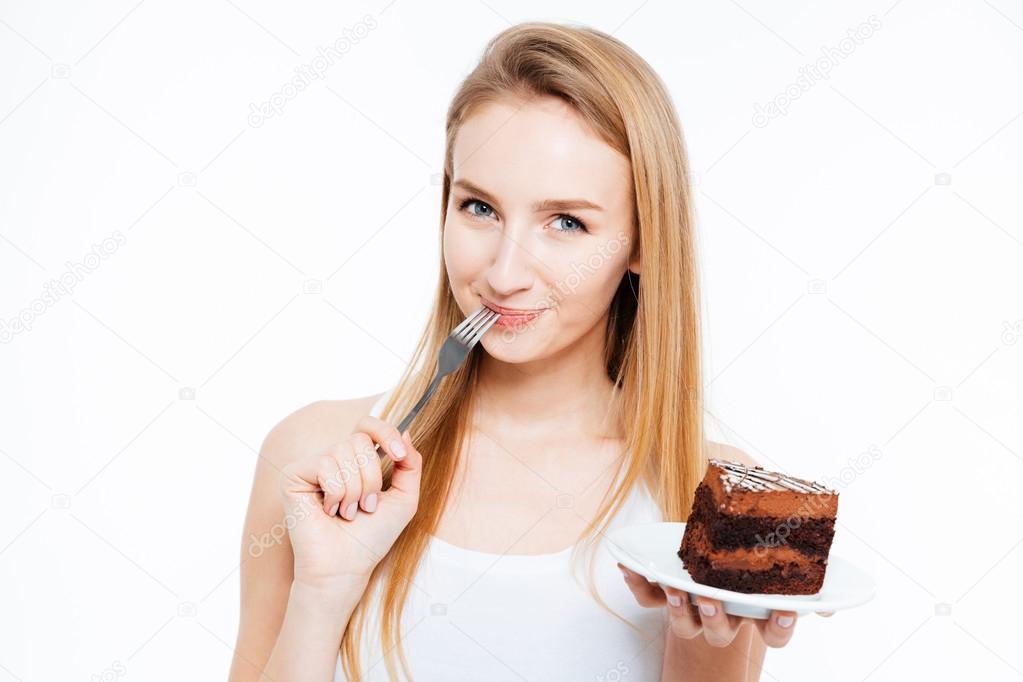 Attractive smiling young woman eating piece of chocolate cake 