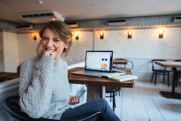 Gladlynt kvinna sitter vid bordet i café — Stockfoto