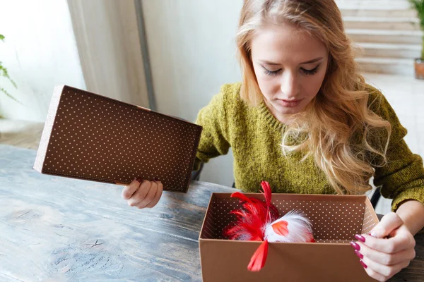 Женщина открывает подарочную коробку — стоковое фото