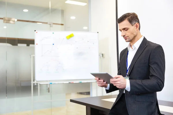 Fokuserad affärsman med tabletten i office — Stockfoto