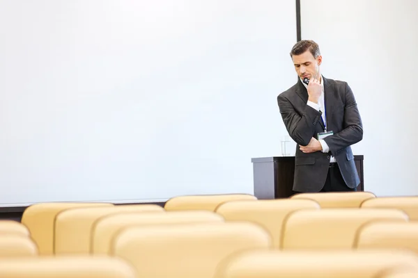 Un uomo d'affari premuroso in piedi in sala conferenze vuota — Foto Stock