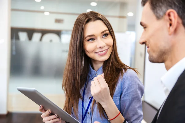 Mujer de negocios hablando con su cliente y utilizando la tableta — Foto de Stock