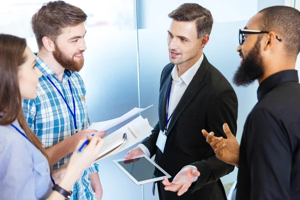 Young business people standing and talking with chief executive — Stock Photo, Image
