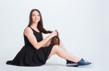 Gülümseyen kadın oturuyordu ve uzun saçları ile örgü yapımı 