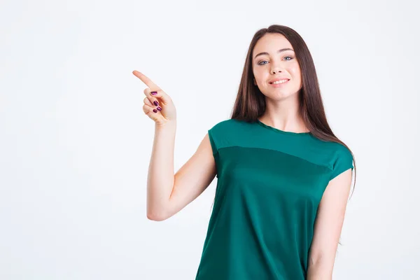 Sorrindo encantadora jovem mulher no topo verde apontando para longe — Fotografia de Stock