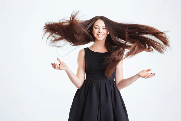 Довольно счастливая молодая женщина с красивыми длинными волосами в движении — стоковое фото
