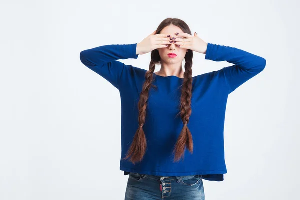 Seriös kvinna med två långa flätor omfattas ögon av händer — Stockfoto