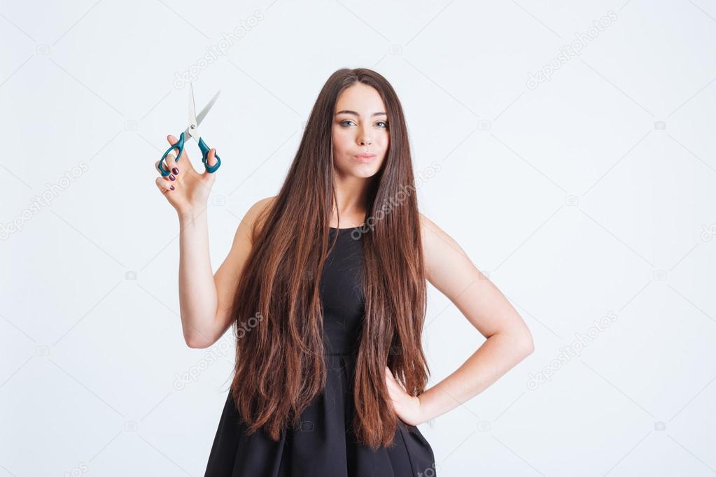 Attractive woman with beautiful long dark hair holding scissors