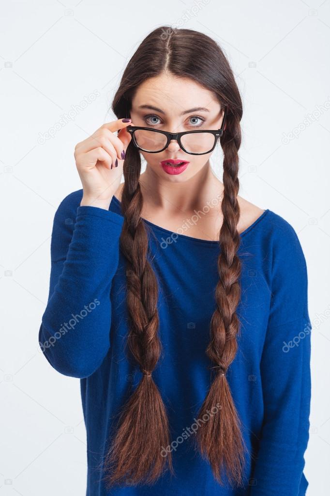 Thoughtul woman with two long braids looking over glasses 