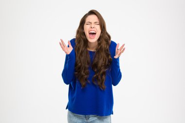 Mad hysterical woman with long curly hair standing and shouting 