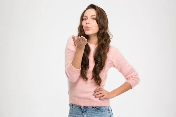 Lovely charming young woman in pink sweatshirt sending a kiss — ストック写真