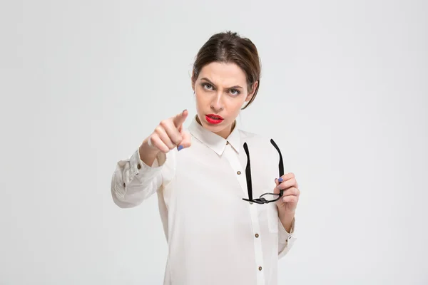 Angry businesswoman pointing finger at camera — Stockfoto