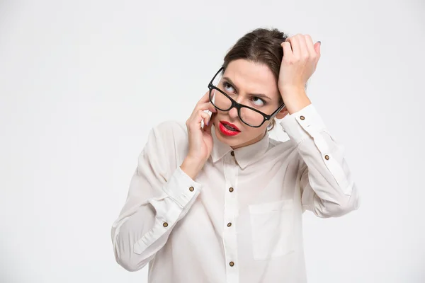 Mujer de negocios reflexiva en gafas pensando y hablando por teléfono —  Fotos de Stock
