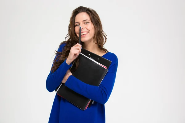 Cute lovely smiling young woman standing with folders and pen — Stockfoto