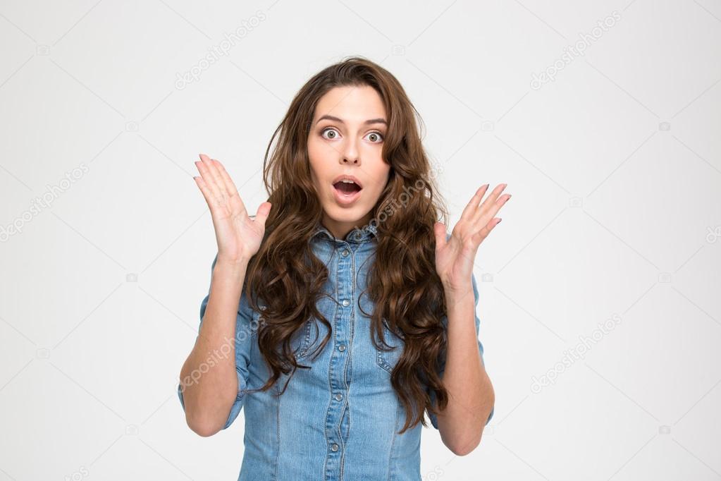 Shocked amazed young woman with raised hands and opened mouth 