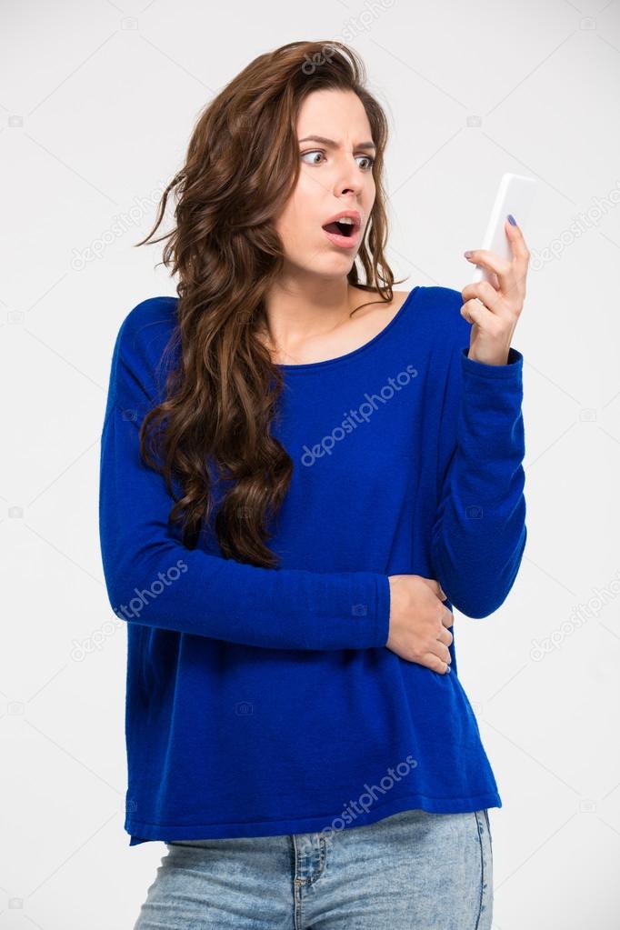 Amazed woman reading message on smartphone