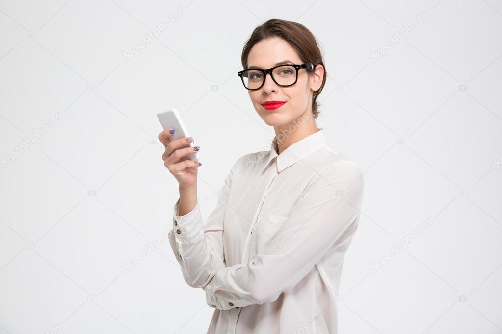 Happy confident young business woman in glasses using smartphone 