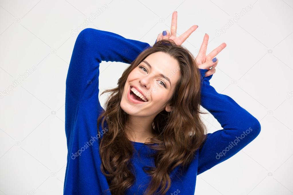 Smiling woman having fun and making horns by her hands 