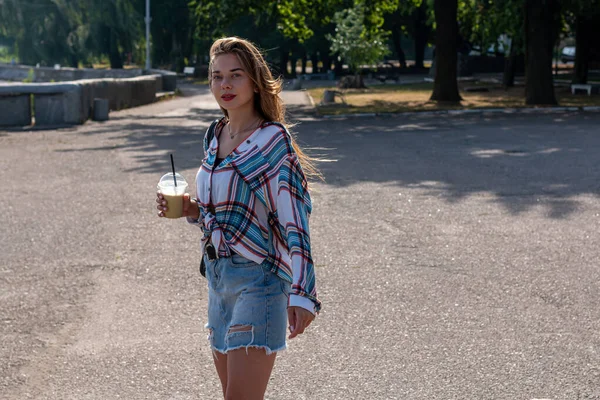 早上公园里穿着休闲装 喝着咖啡鸡尾酒的年轻女子 — 图库照片