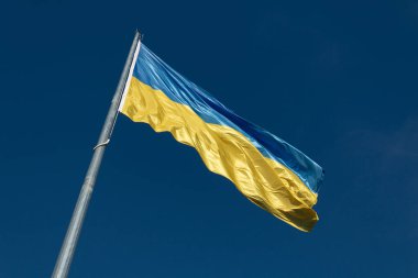 Büyük ulusal Ukrayna bayrağı mavi gökyüzünde dalgalanıyor