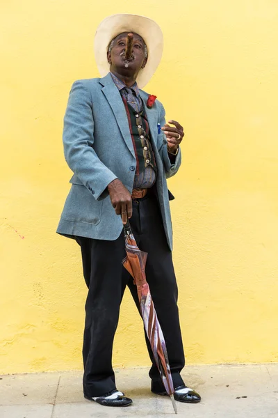 Homem cubano tradicional fumar charuto cubano grande na parede amarela ba — Fotografia de Stock
