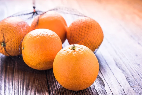 Fresh oranges in shopping net or bag — Stock Photo, Image