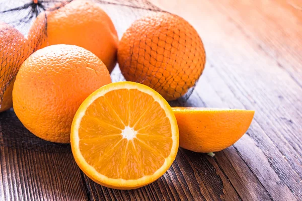 Fresh oranges in shopping net or bag — Stock Photo, Image