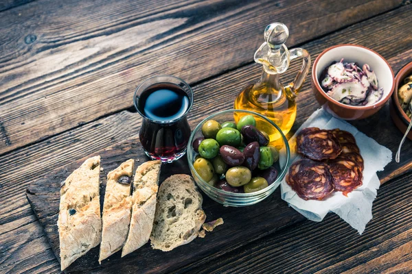 Äkta spanska tapas på träplatta, tonned bild — Stockfoto