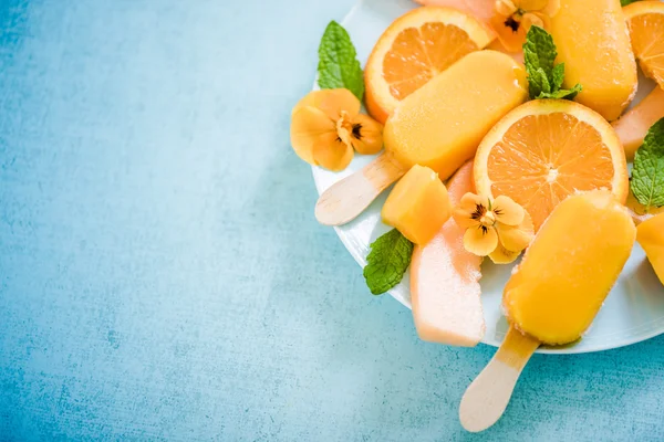 Ghiaccioli arancioni con frutta fresca — Foto Stock