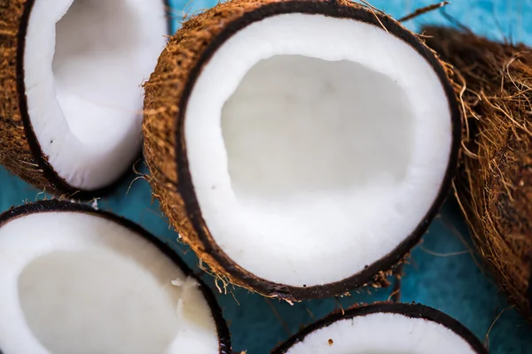 Połówki orzecha kokosowego na niebieskim tle — Zdjęcie stockowe
