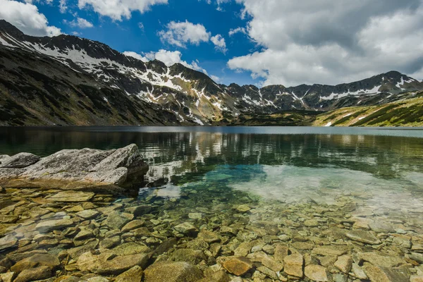 Reflexão de montanhas no lago alpino no dia ensolarado — Fotografia de Stock