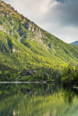 Geleneksel ahşap ev ve dağ yansıma göl