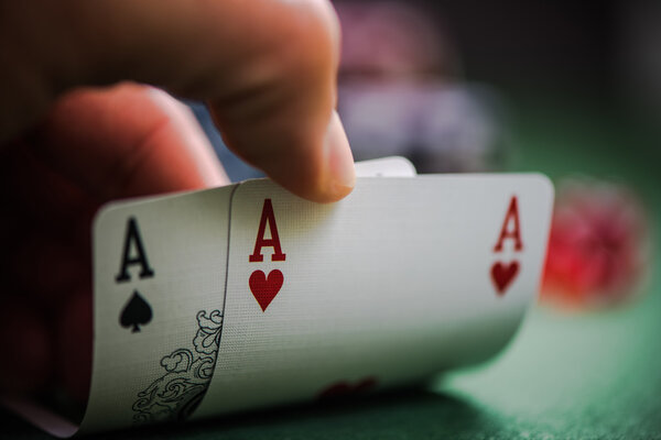 мужчина показывает две асы в покер

