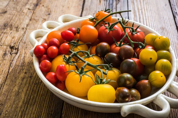 Seleção de tomates em tigela rústica — Fotografia de Stock