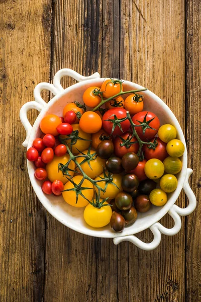 Seleção de tomates em tigela rústica — Fotografia de Stock